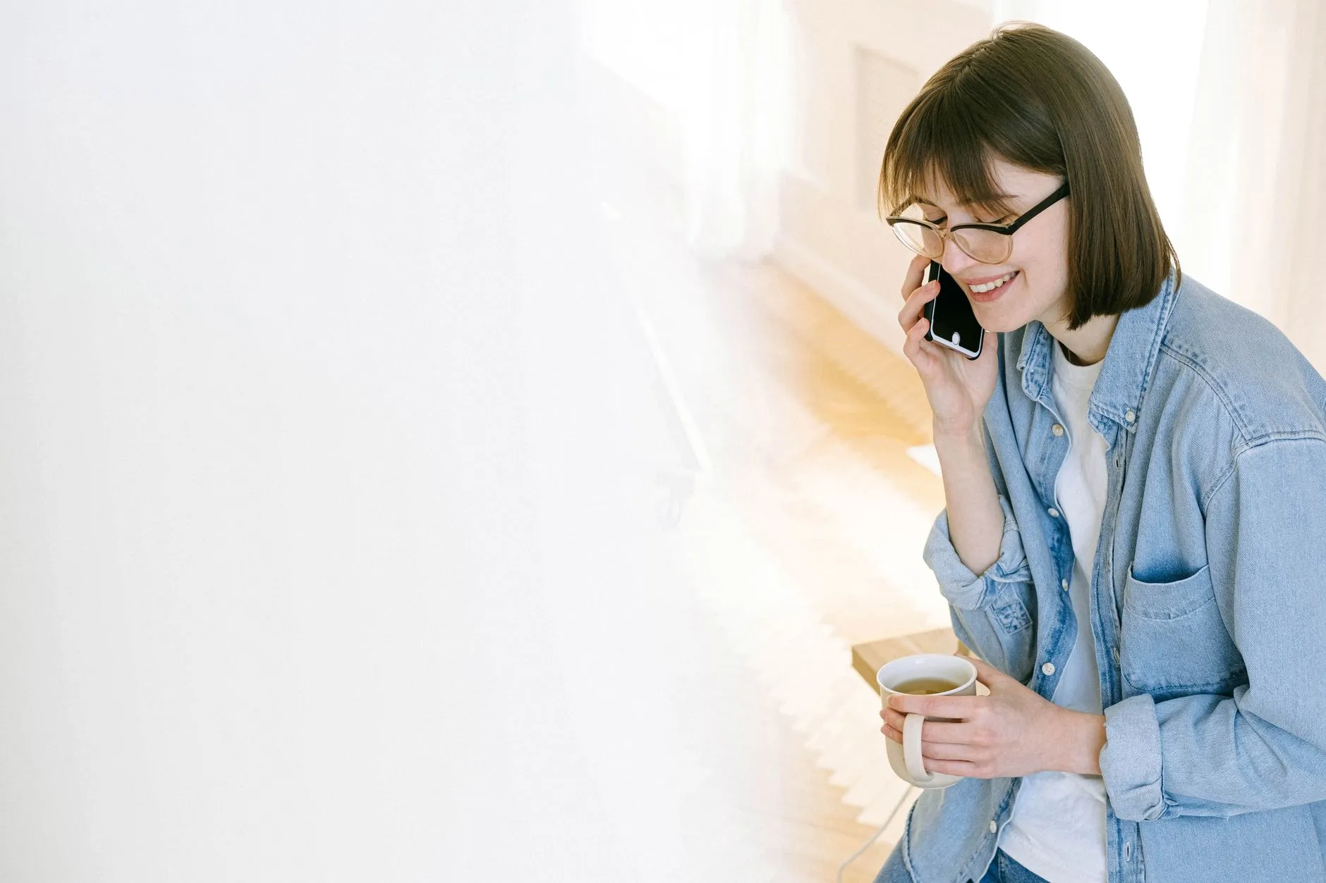 A person on the phone in warm morning light, reaching out for help.